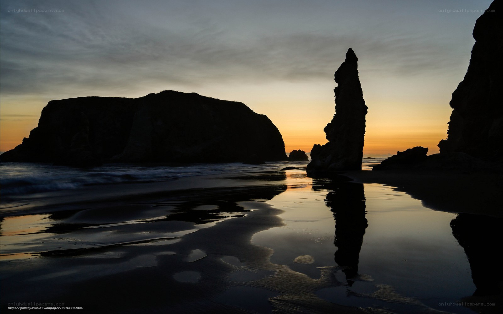 Silhouetted sea stacks at sunset