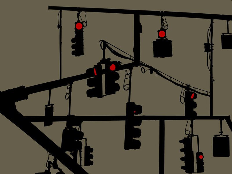 Silhouetted traffic lights at intersection