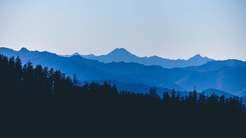 Silhouetted Trees and Mountains — Blue, Serene, Morning, Photograph, Sky