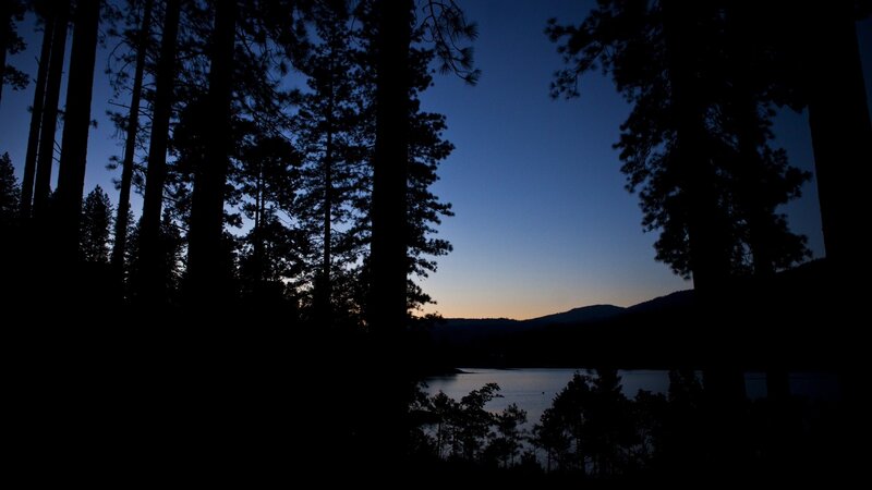 Silhouetted Trees at Lake — Blue, Serene, Sunset, Photograph, Mountains