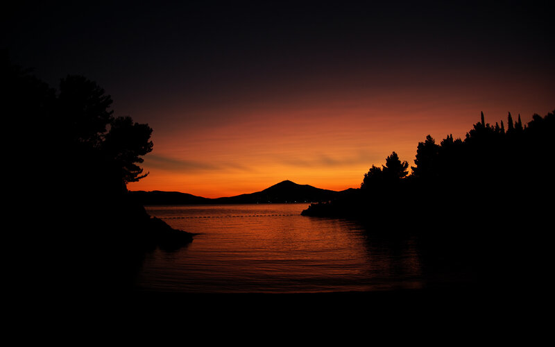 Silhouetted Trees at Sunset — Orange, Serene, Photograph, Mountain, Water, Sky