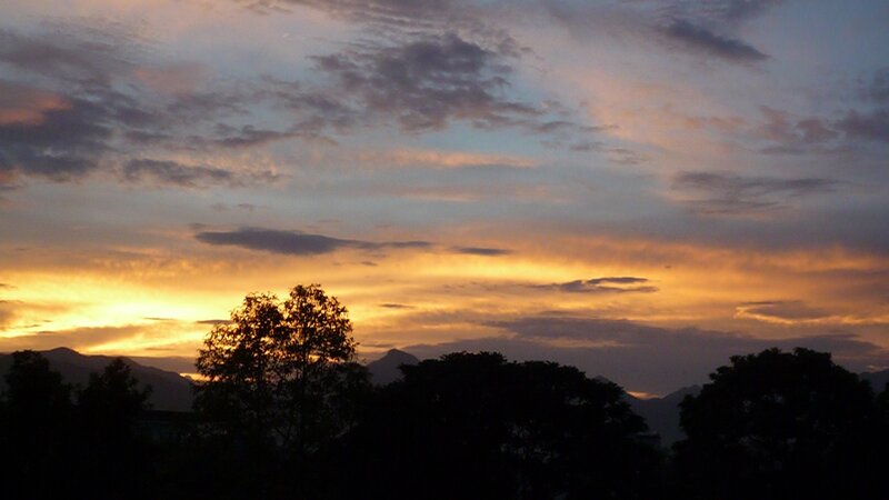 Silhouetted Trees at Sunset — Orange, Serene, Photograph, Mountains, Clouds