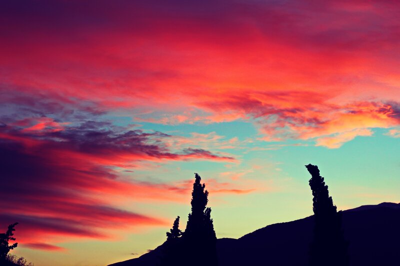 Silhouetted Trees at Sunset — Red, Dramatic, Photograph, Mountains, Clouds
