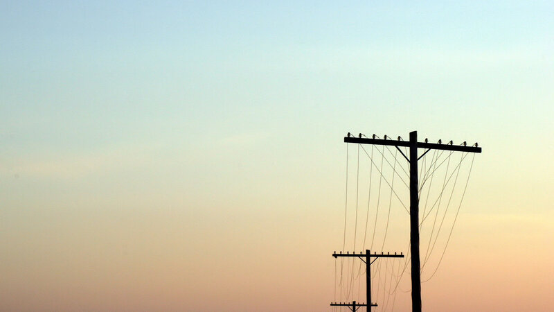 Silhouetted utility poles at dusk