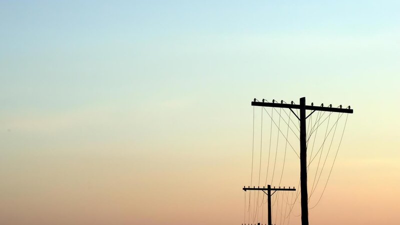 silhouetted utility poles at dusk