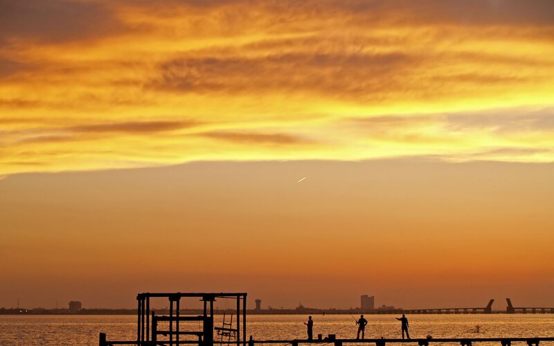 Silhouettes at sunset by the water