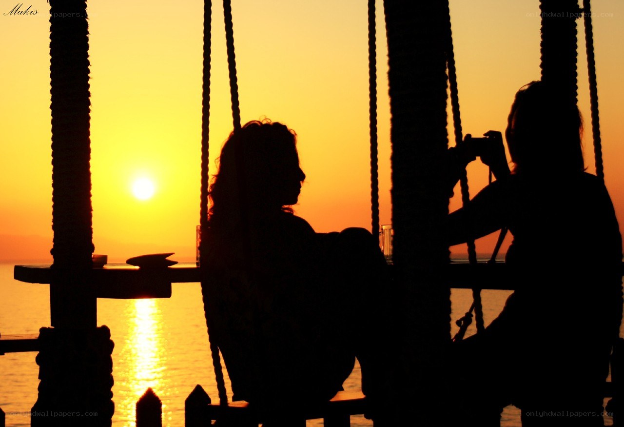 Silhouettes at sunset by the water