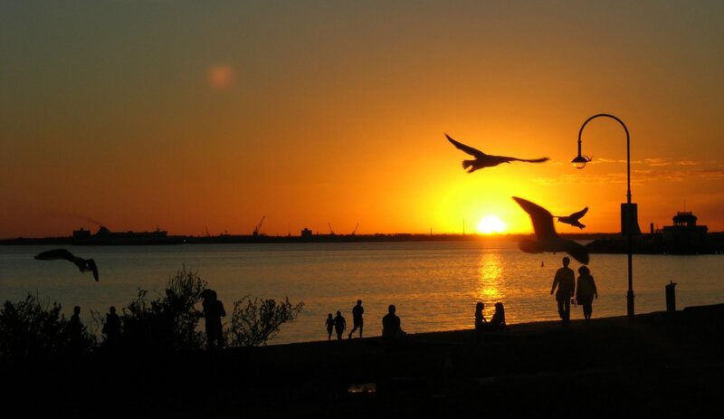 Silhouettes at sunset by the water