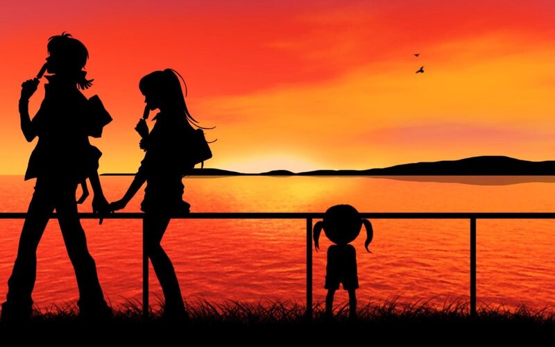 Silhouettes at sunset by the water