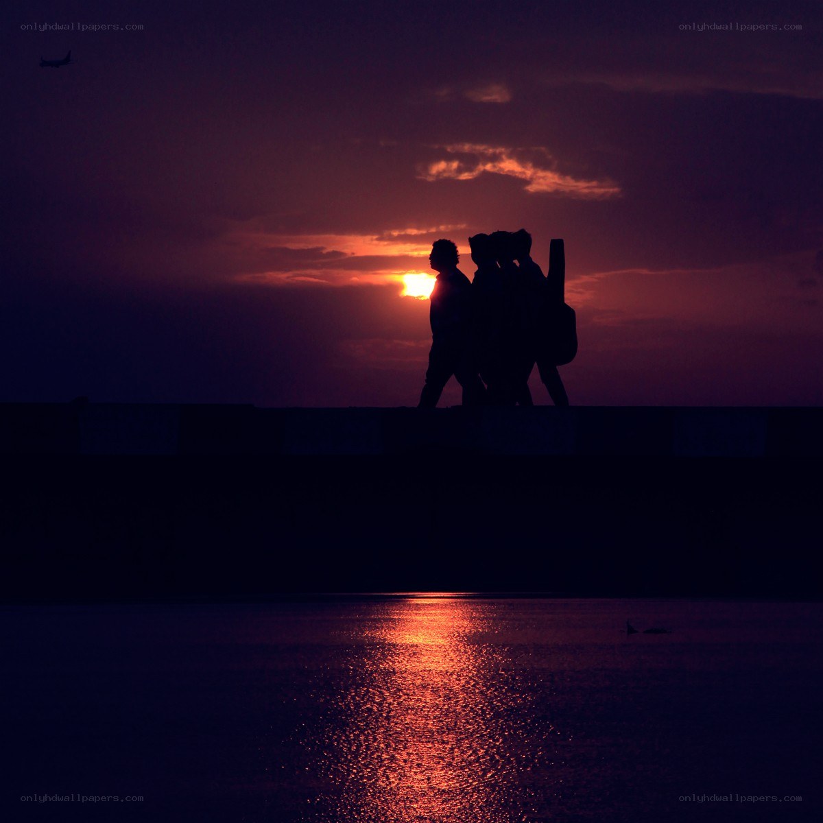 silhouettes at sunset by water