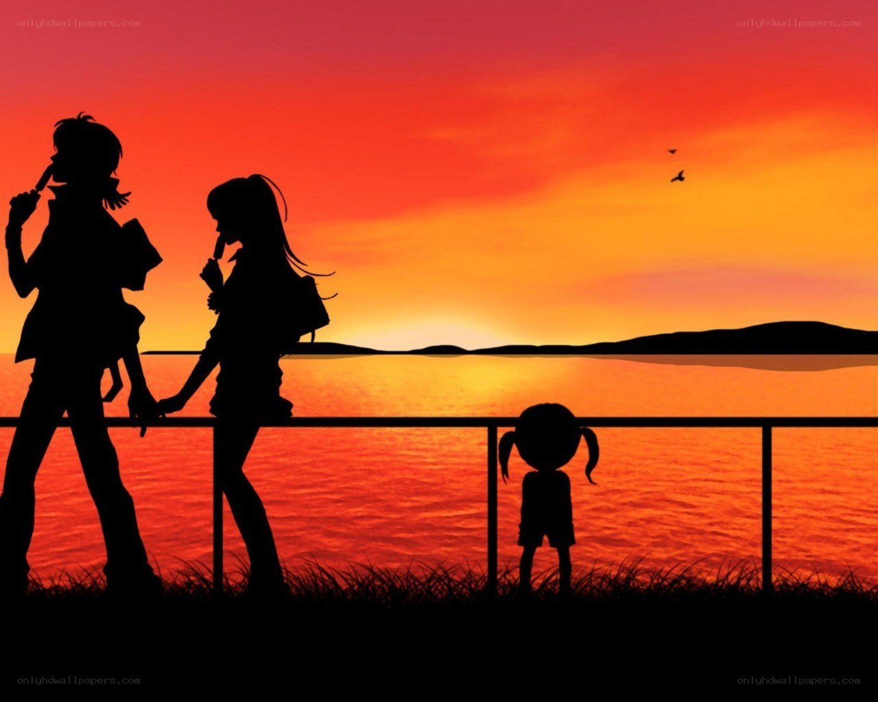 Silhouettes at sunset by water