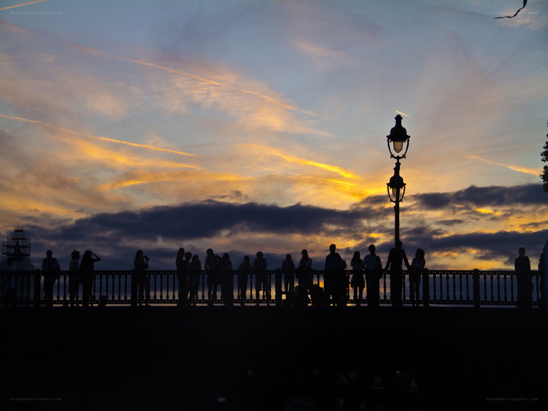 Silhouettes at sunset on a bridge