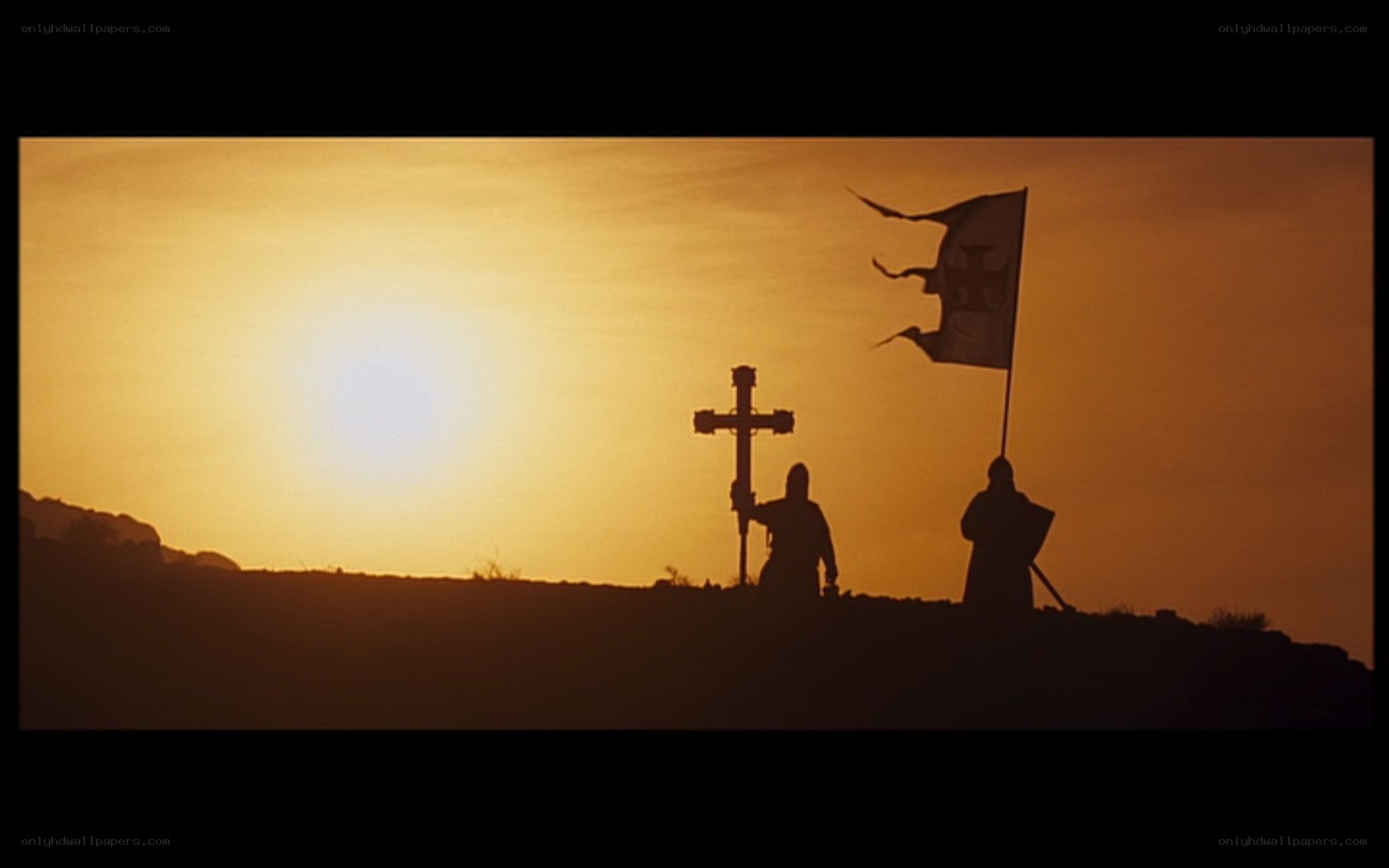 Silhouettes at sunset with cross and flag