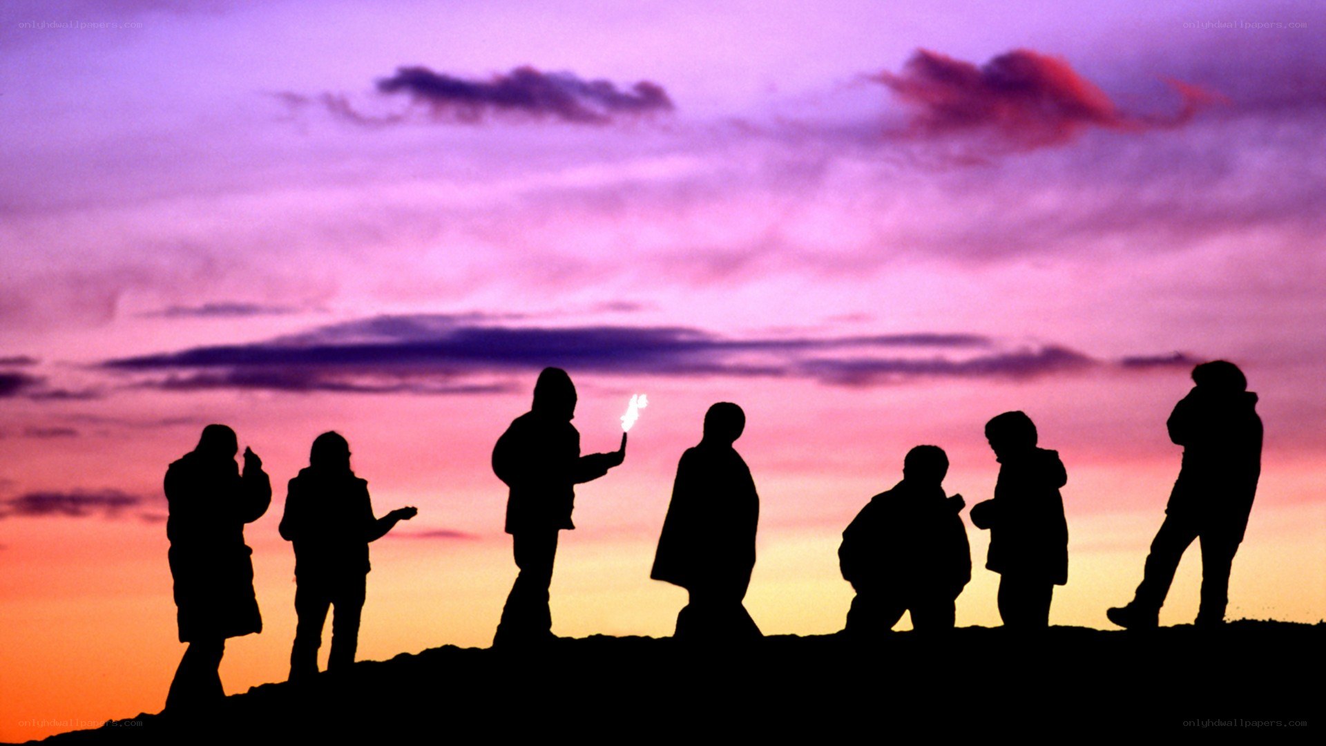 Silhouettes at sunset with sparkler