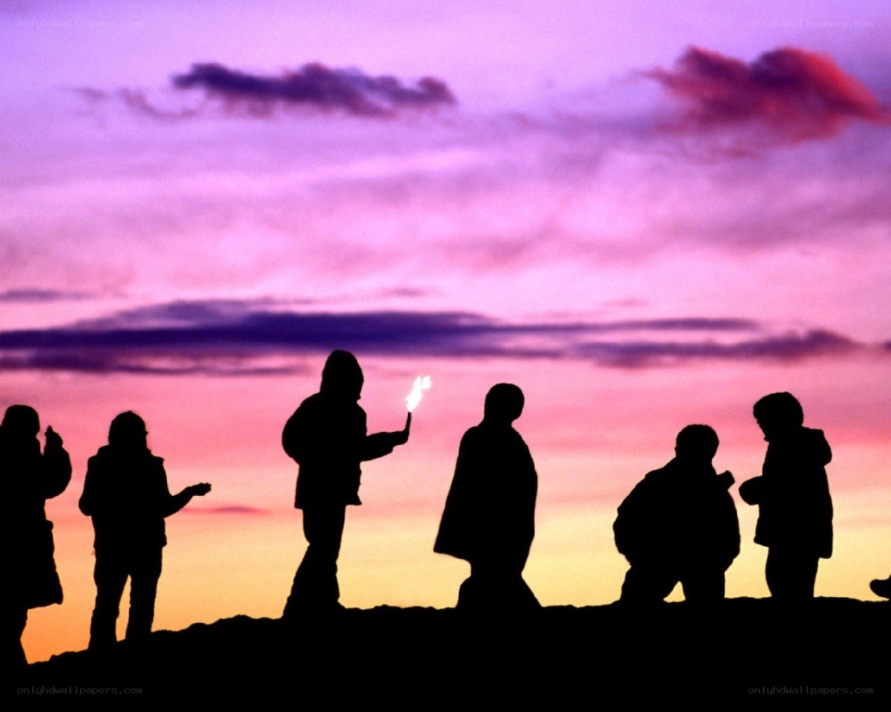 Silhouettes at sunset with sparkler
