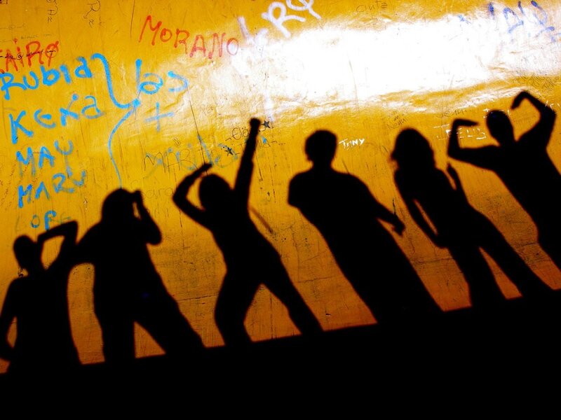 Silhouettes dancing on a graffiti wall