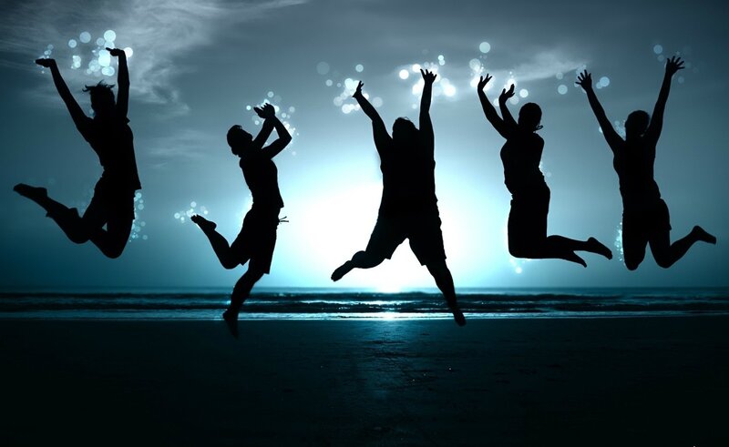 silhouettes jumping on beach