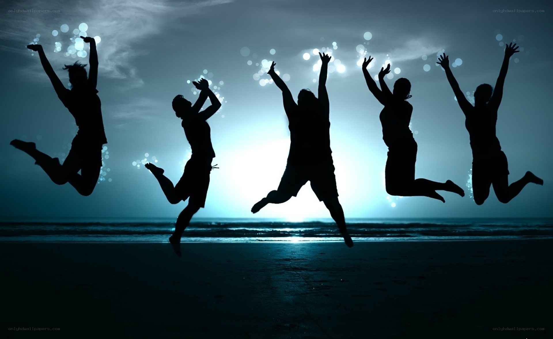 silhouettes jumping on beach