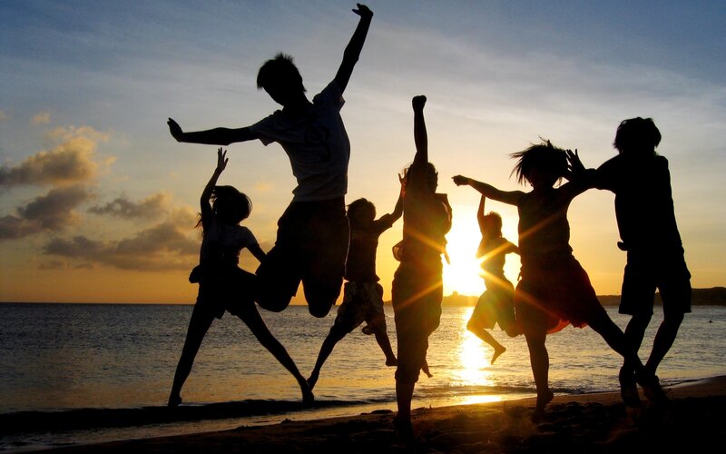 Silhouettes of children jumping at sunset