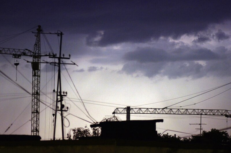 Silhouettes of cranes and power lines