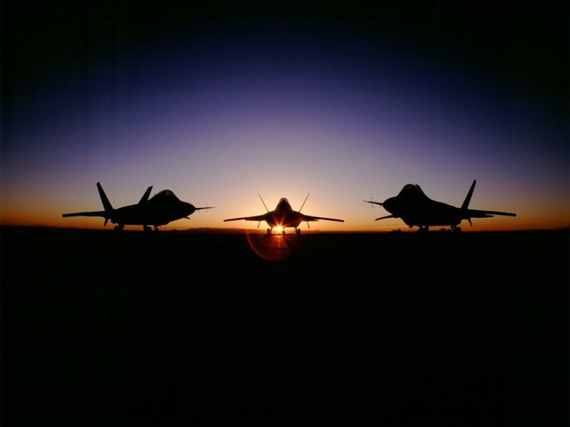Silhouettes of fighter jets at sunset