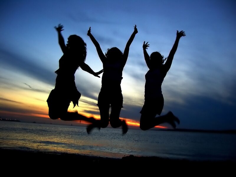 silhouettes of friends jumping at sunset