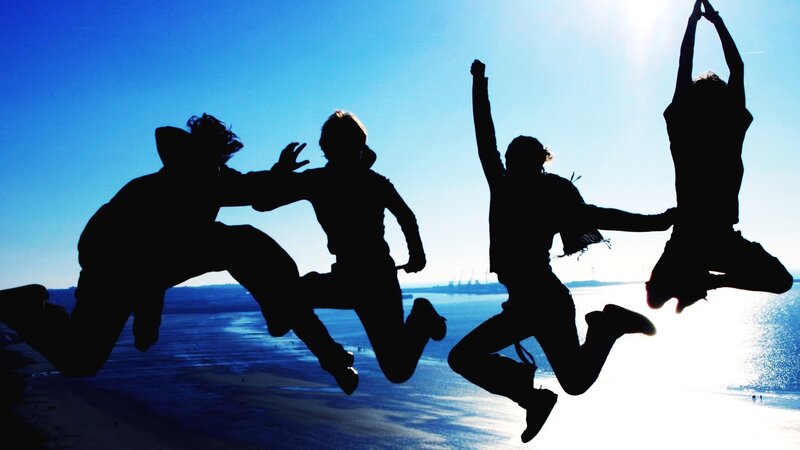 silhouettes of friends jumping