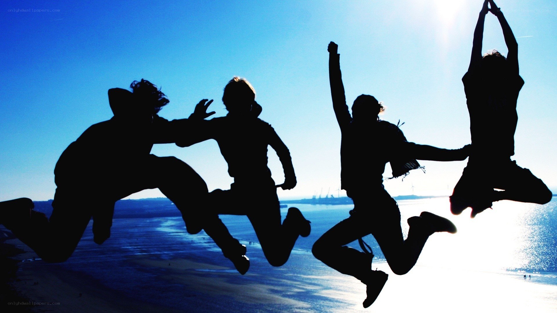 silhouettes of friends jumping
