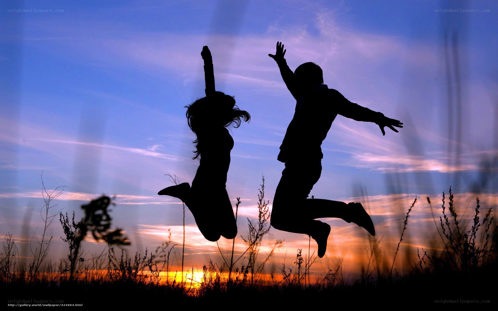Silhouettes of jumping couple