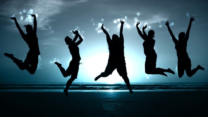 silhouettes of people jumping on beach