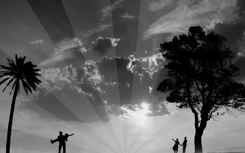 Silhouettes of people under a cloudy sky