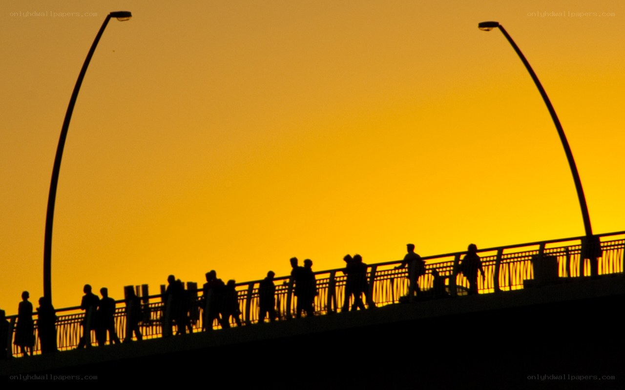 Silhouettes on a bridge at sunset
