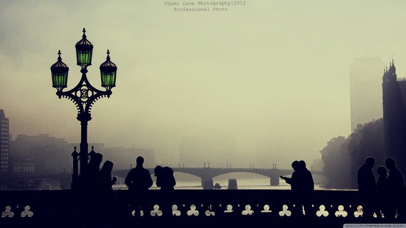 Silhouettes on a foggy London bridge