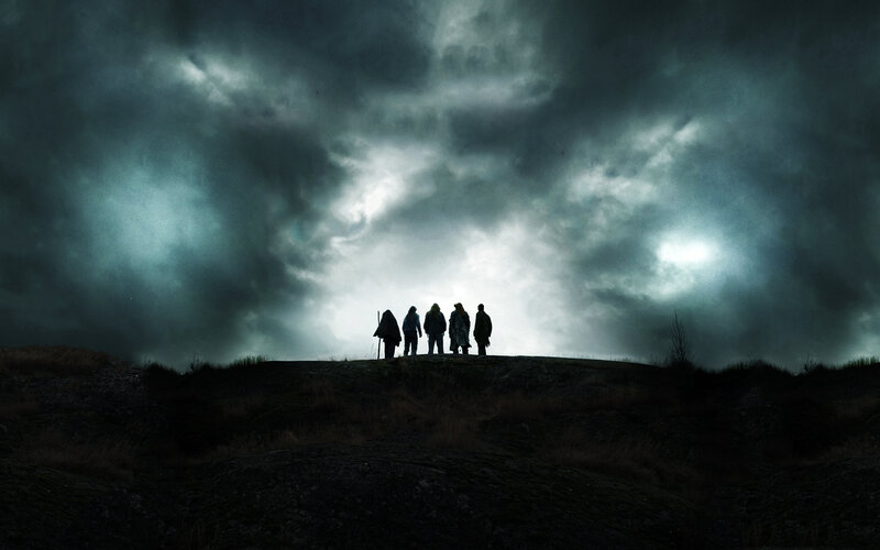 Silhouettes on a hill under stormy sky