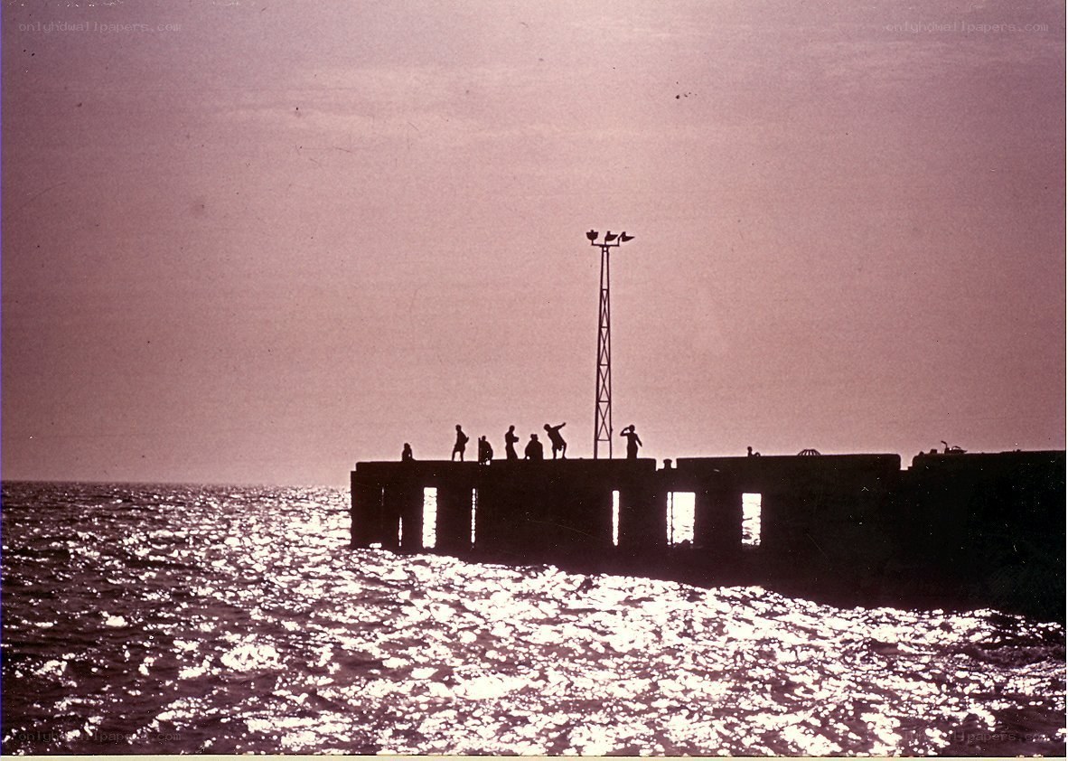 Silhouettes on a pier at sunset