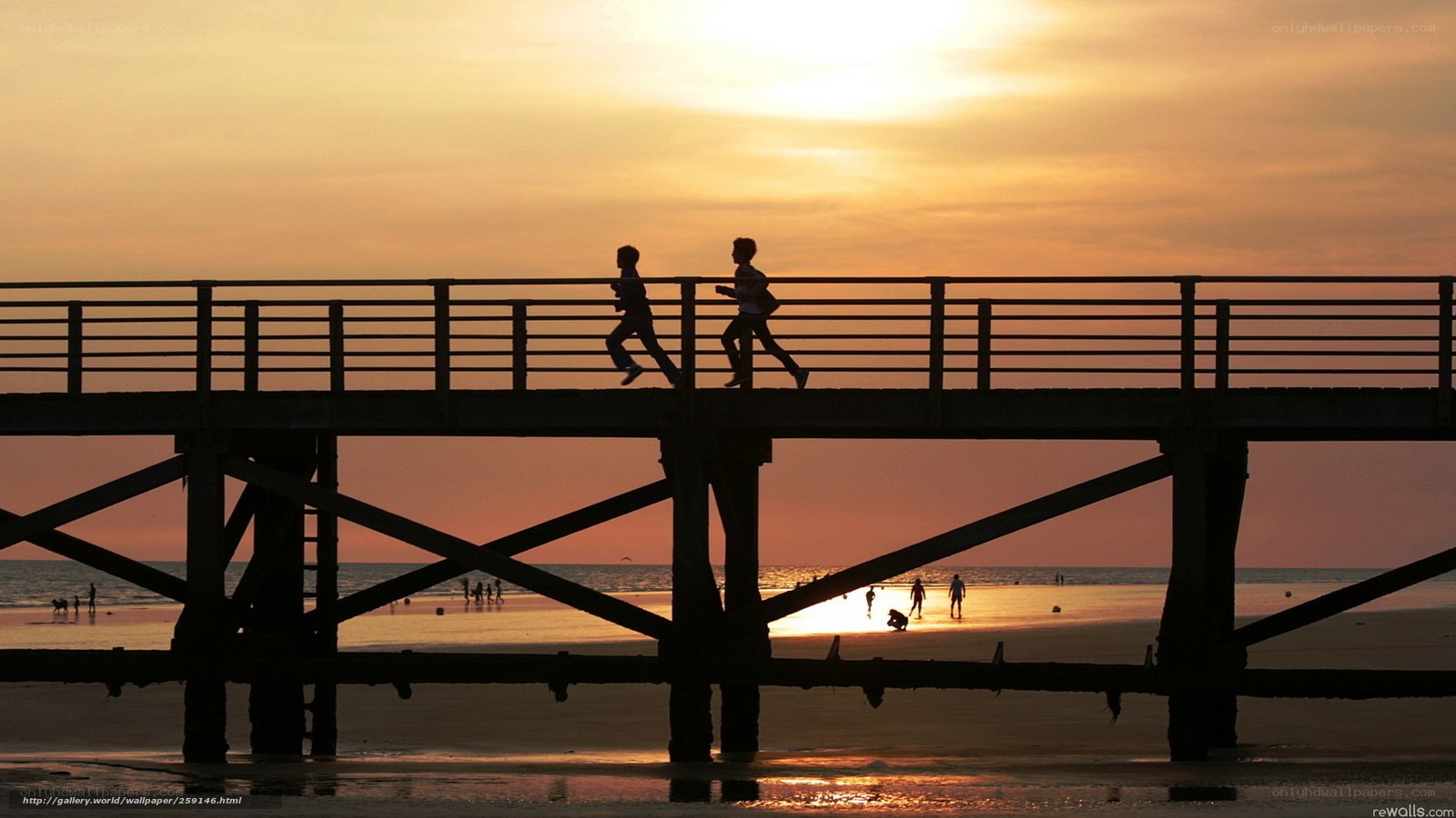Silhouettes on a pier at sunset