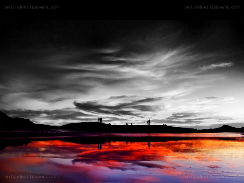 silhouettes on a red-lit beach