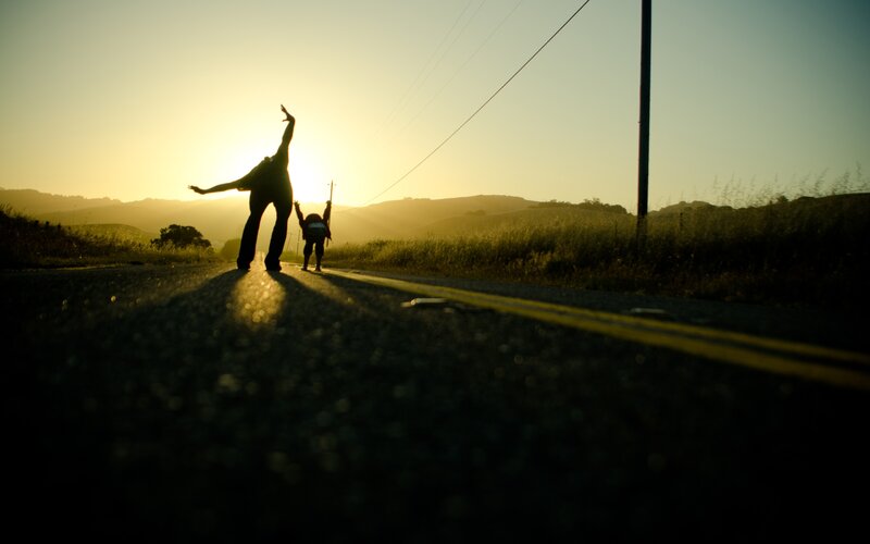 Silhouettes on a road at sunset