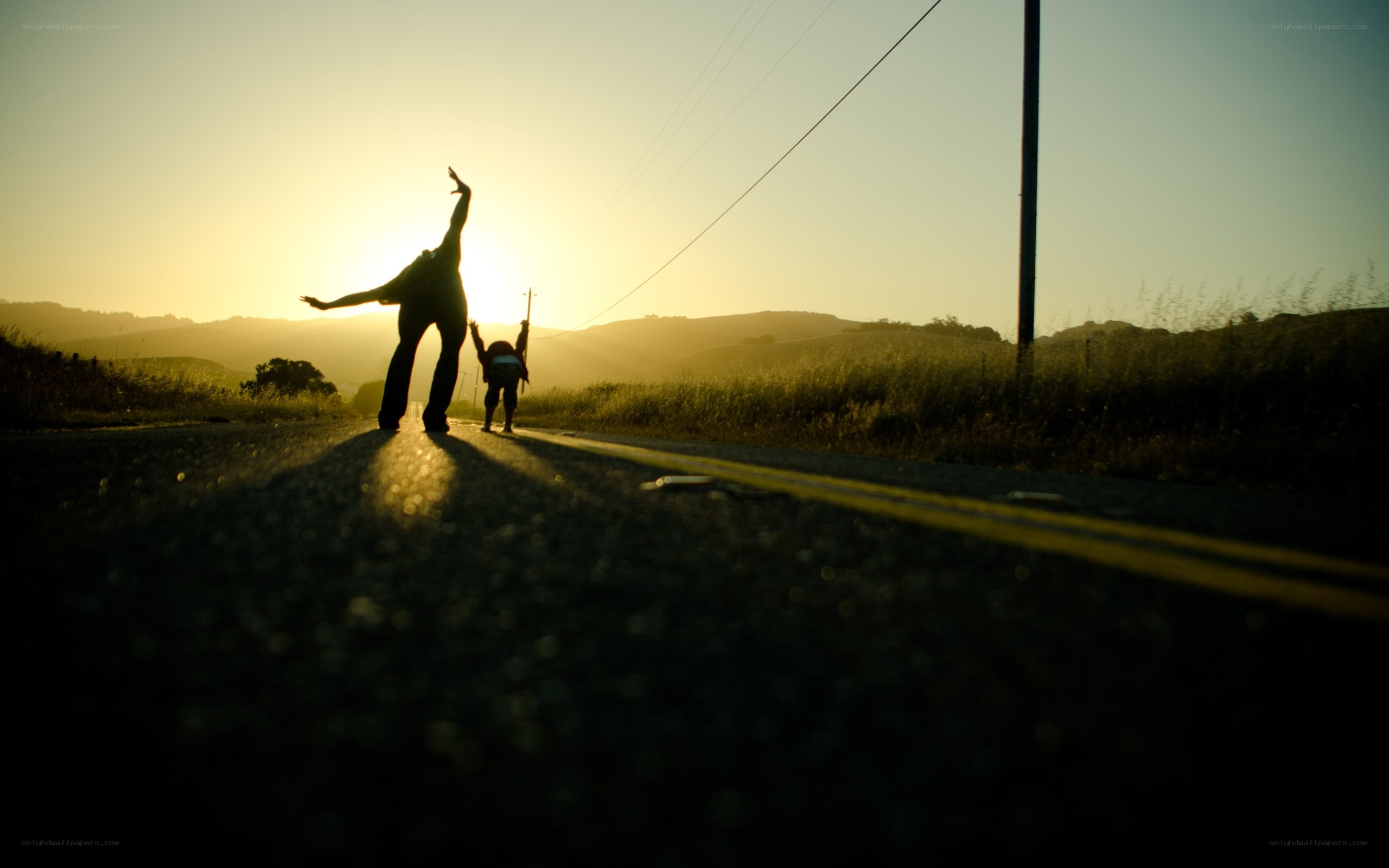 Silhouettes on a road at sunset
