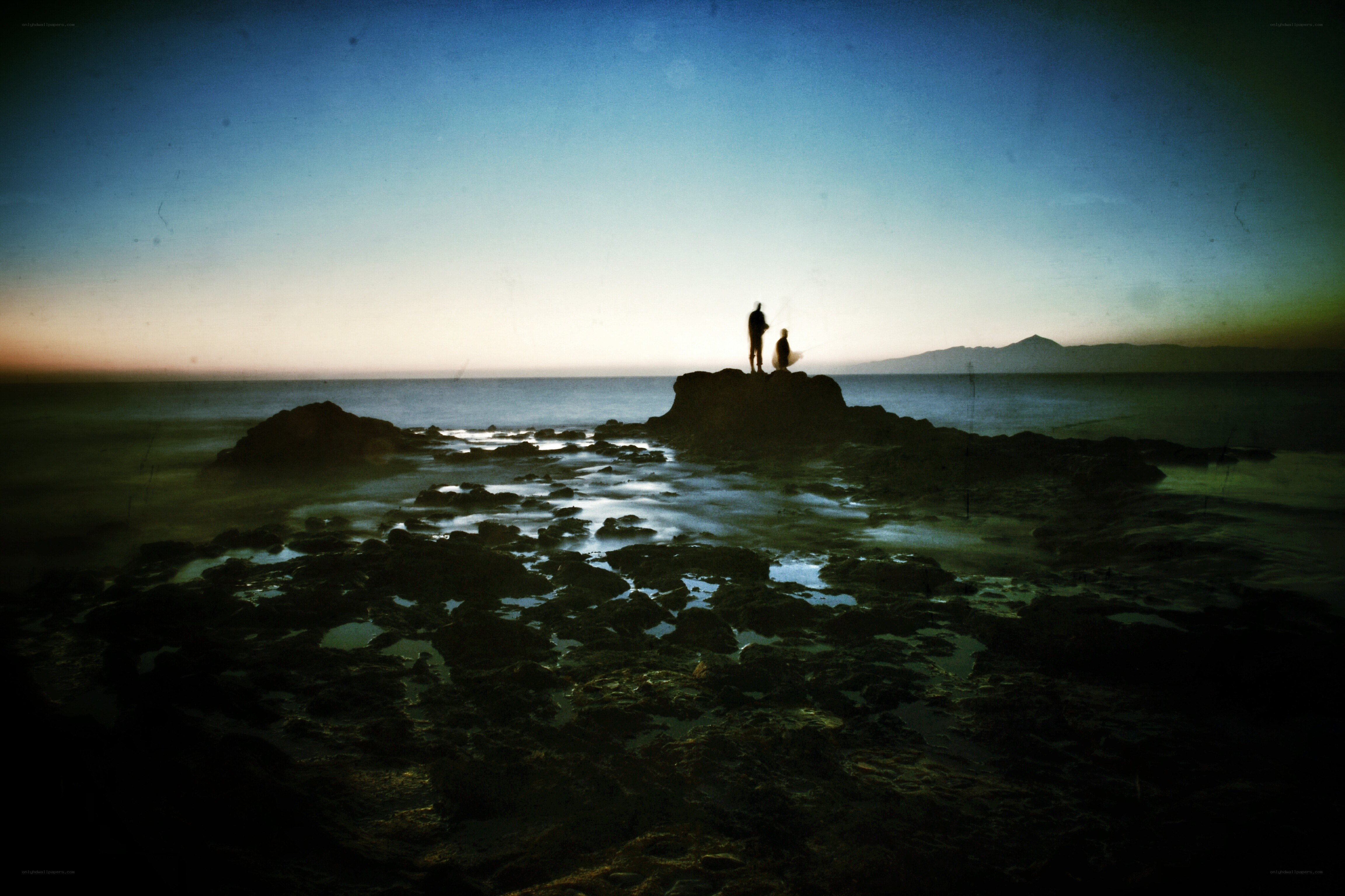 Silhouettes on a rocky shore