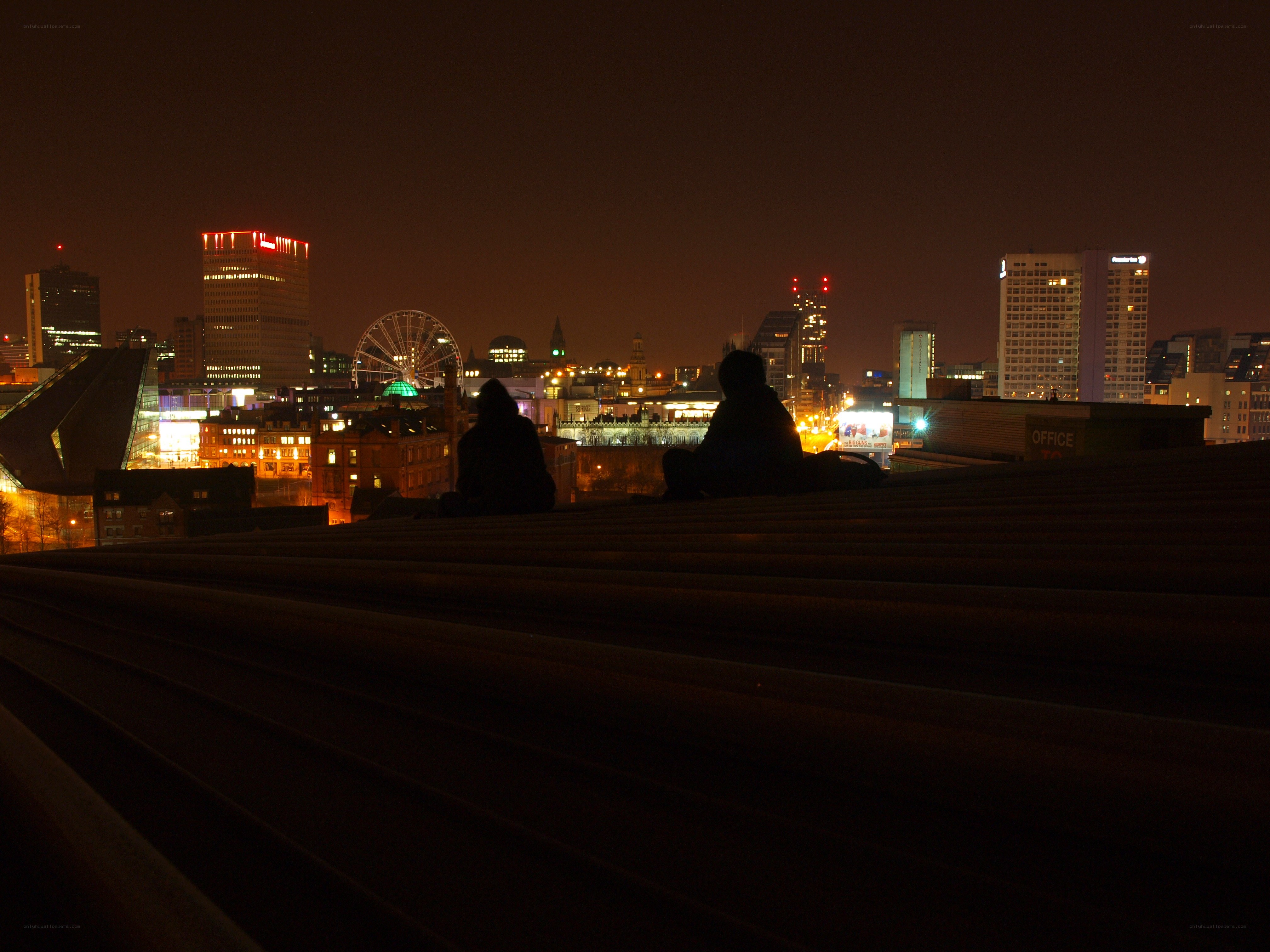 Silhouettes on a rooftop at night