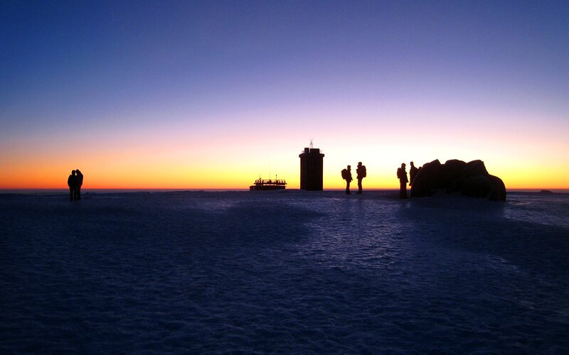 Silhouettes on a snowy landscape at sunset