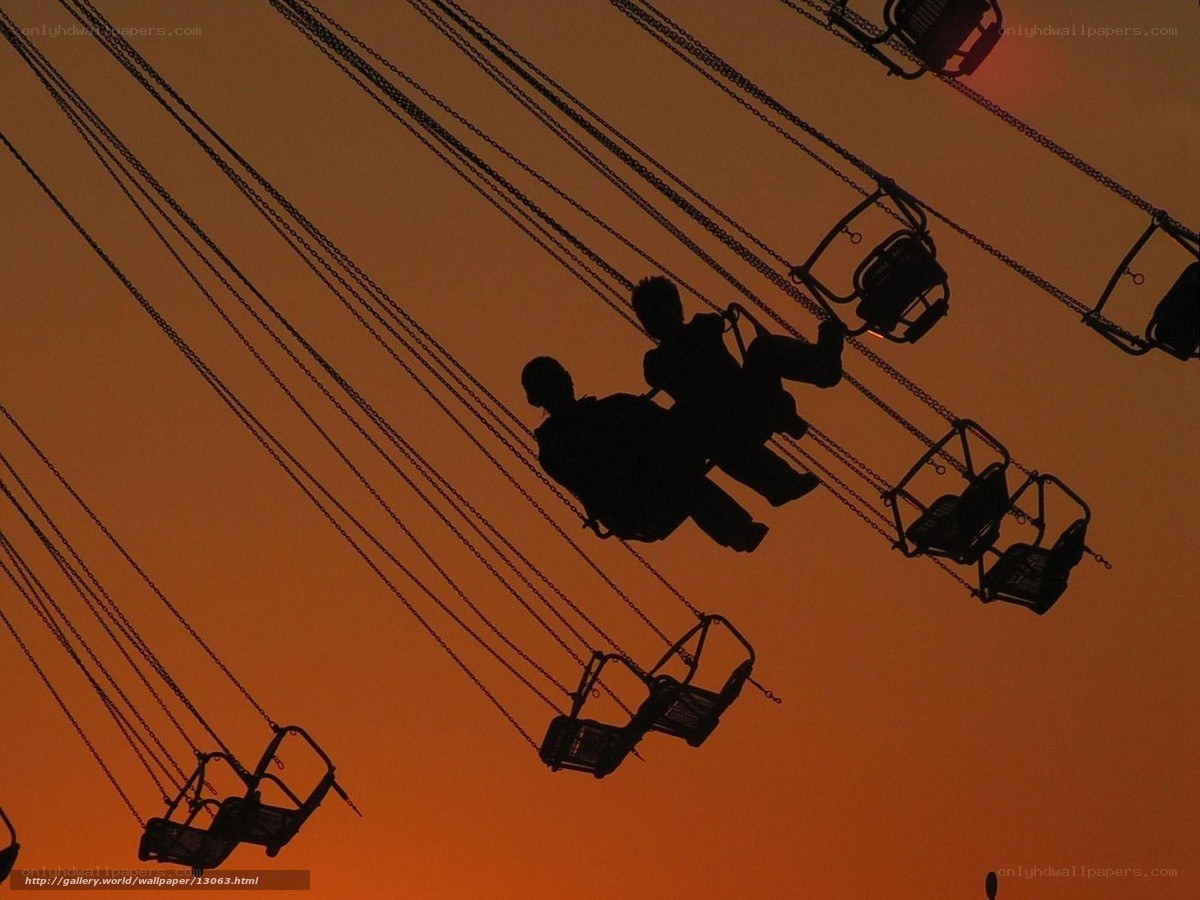 Silhouettes on a swing ride