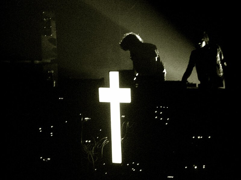 Silhouettes on stage with glowing cross