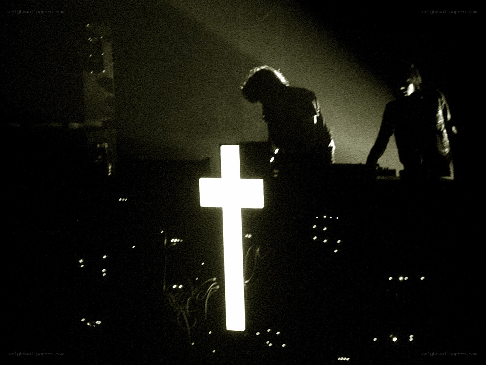 Silhouettes on stage with glowing cross