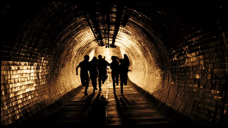 Silhouettes Running in Tunnel