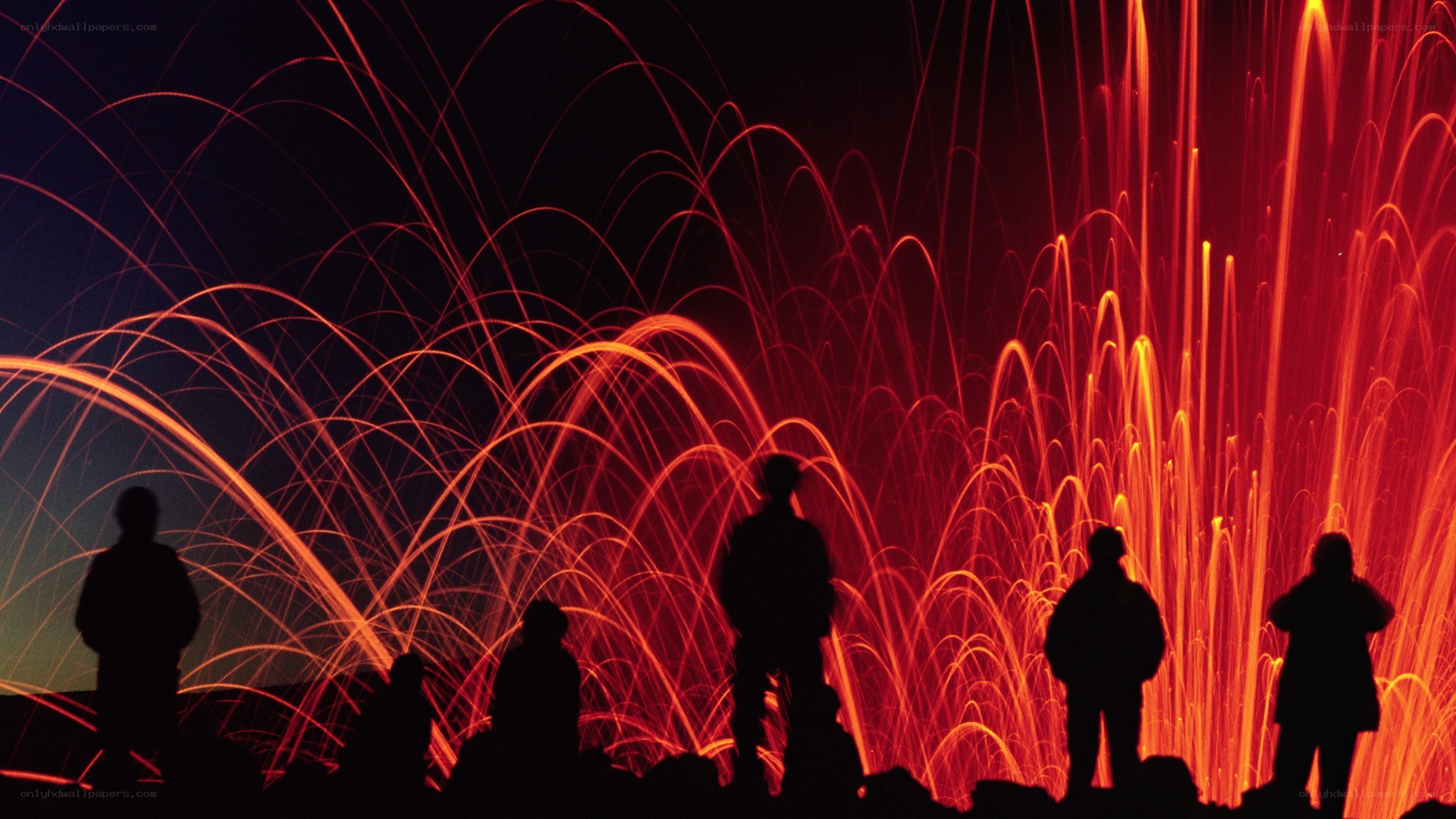 Silhouettes watching firework display