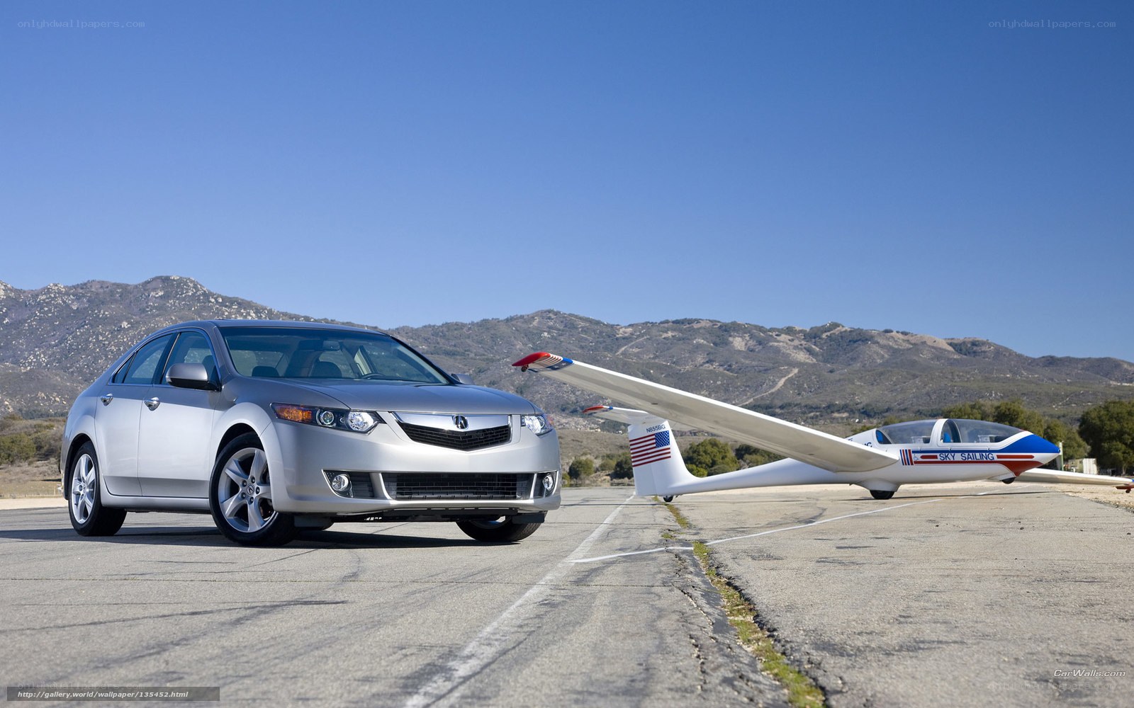 Silver Acura and glider on tarmac
