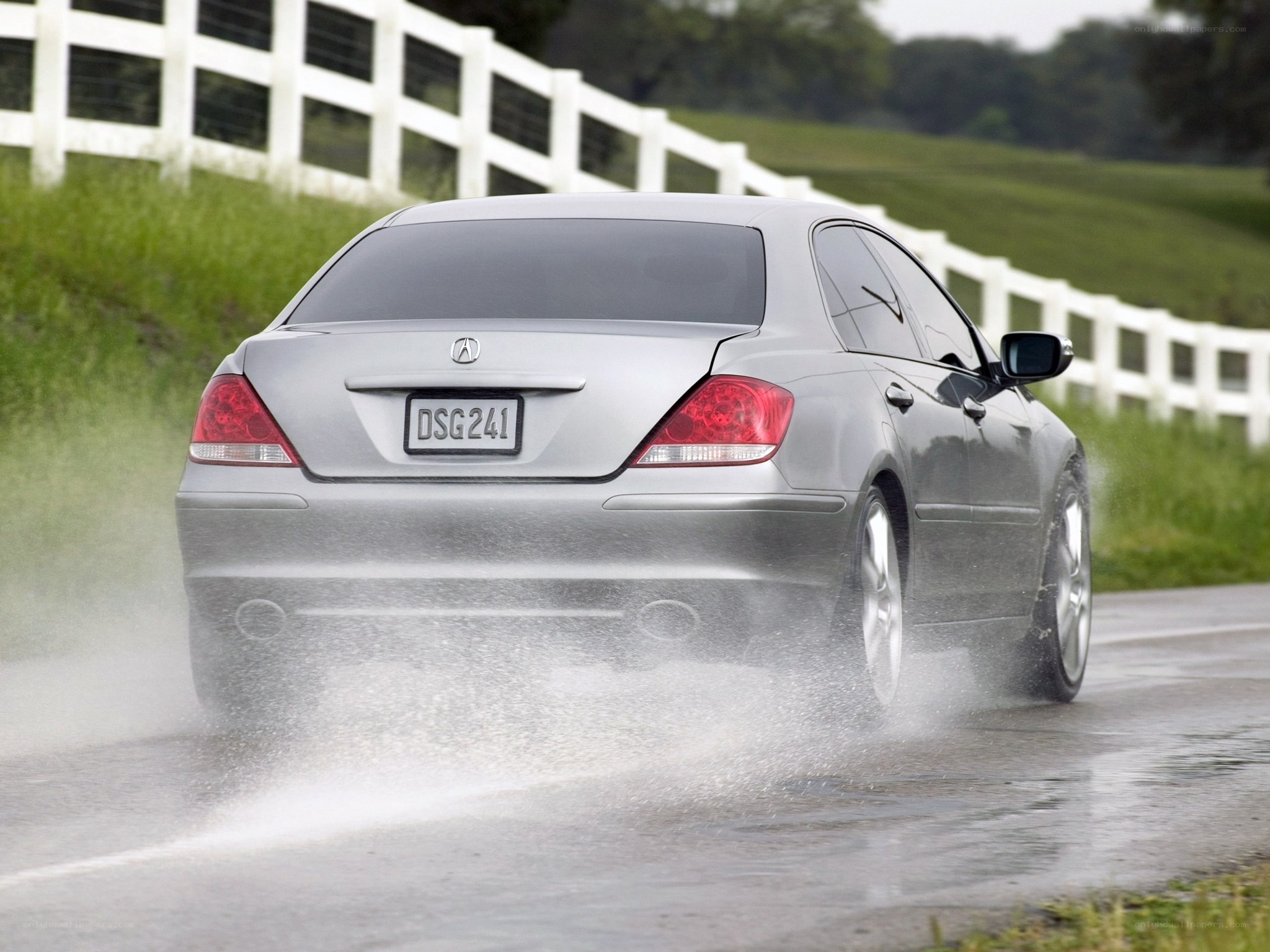silver acura driving on wet road