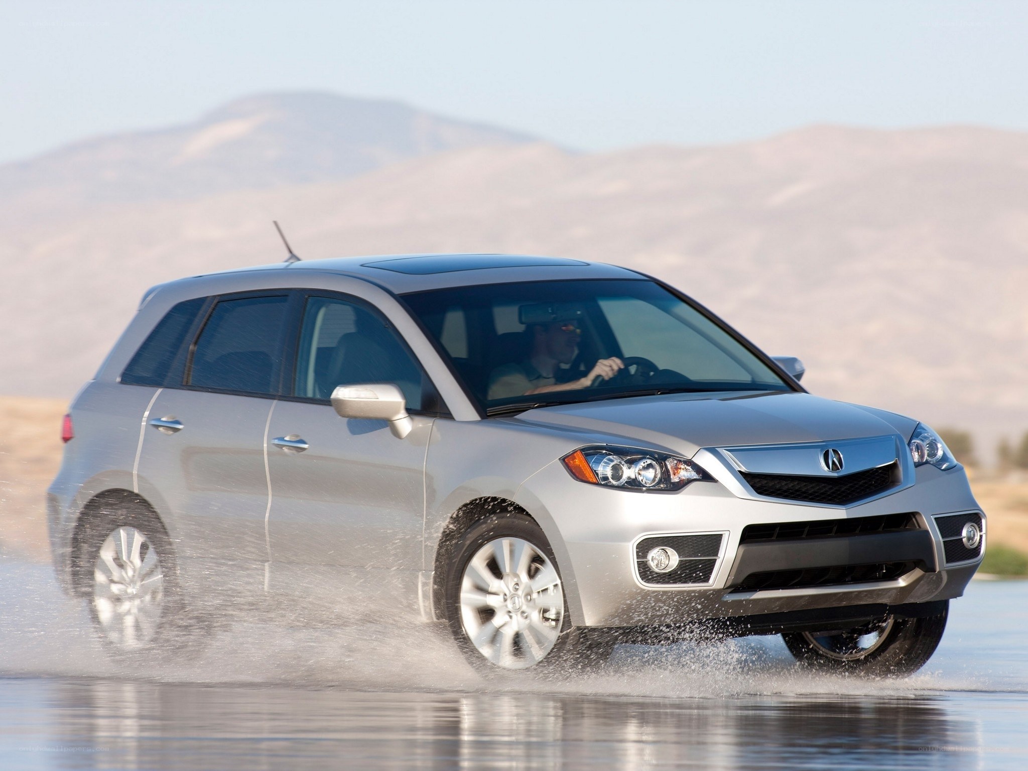 silver acura driving through water